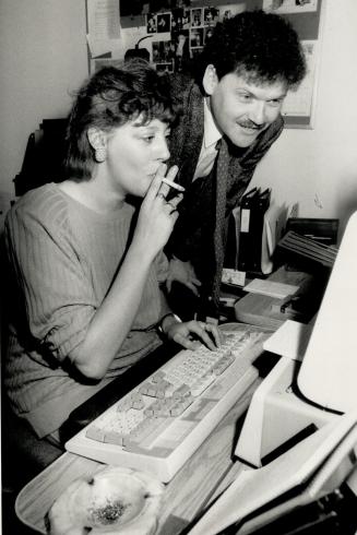 Some disagree: While Executive Alderman Chris Korwin-Kuczynski looks over her shoulder, secretary Rita Olejko takes a puff