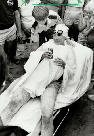 Heroine's welcome: Crowds cheer Marilyn Korzekwa after a triumphant swim of Lake Ontario and mom Irene wades out with a towel, above