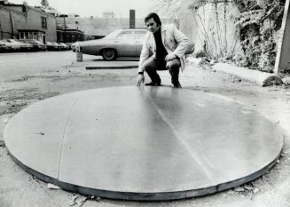 Gallery owner Carmen Lamanna inspects sculpture of artist David Rabinowitch on a dusty parking lot just south of Davenport