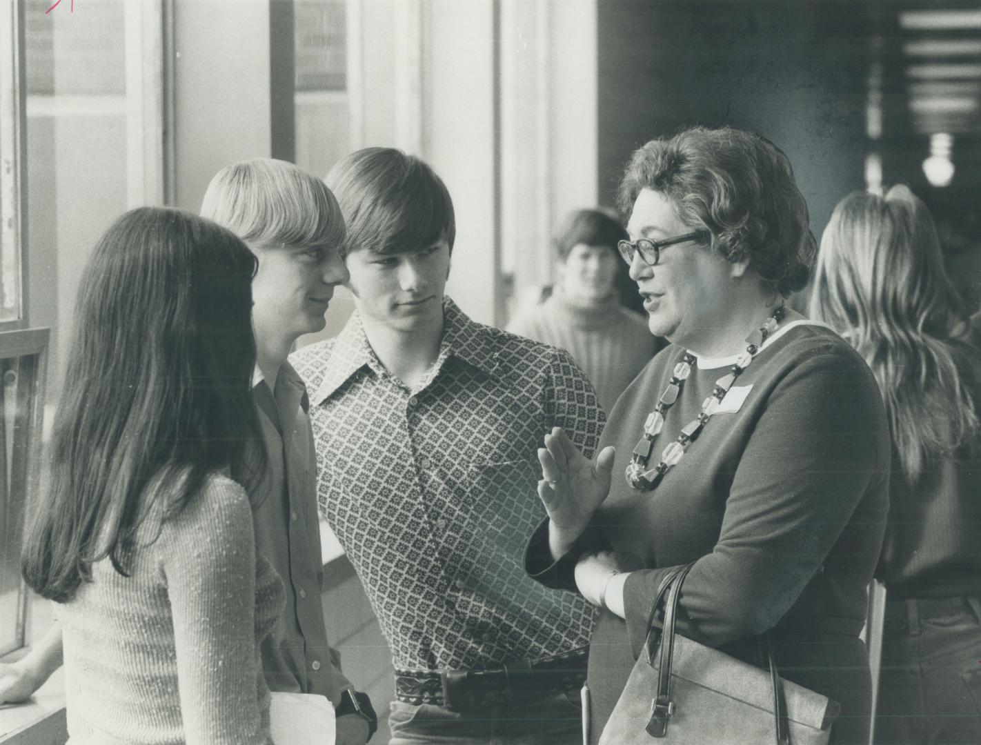 Judy LaMarsh, the former federal cabinet minister who wrote the best-selling book A Bird in a Gilded Cage, talks in a hallway to three students