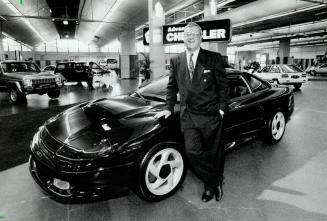 Stealth unveiled: Chrysler Canada president Yves Landry is shown with new four-seat Dodge Stealth sports car, unveiled yesterday at a news conference