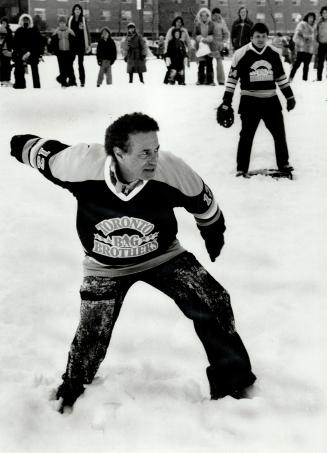 Winding up: Mayor Mel Lastman prepares to hurl his slow curve ball during a chilly softball game in which players often slipped and fell on their way around the bases