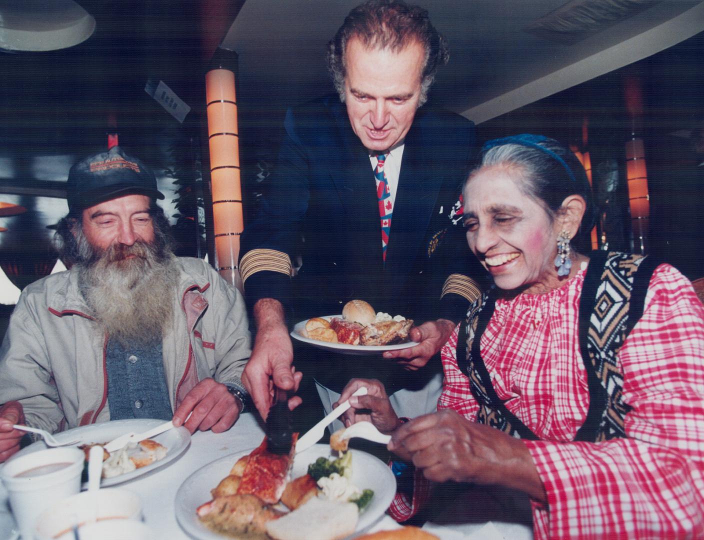 Restaurateur Captain John Letnik serves up a fine feast yesterday to Wes and Shirley, in the third annual lunch for needy people at Captain John's restaurant on Queen's Quay