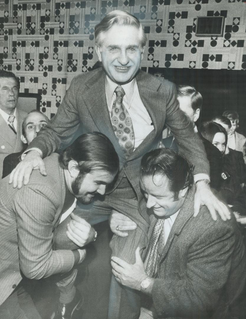 NDP leader David Lewis, who will hold balance of power in the new Parliament, is hoisted on to the shoulders of Vern Titus and Jack Matraia at Lewis' headquarters on Dufferin St