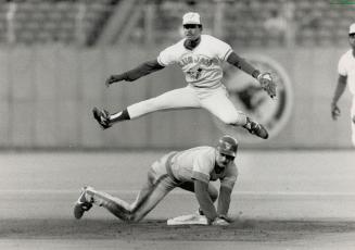 Leapin' Liriano: Toronto second bagger Nelson Liriano steps on the bag and then turns on the acrobatics, to avoid Milwaukee baserunner Rob Deer and fire to first for the double play