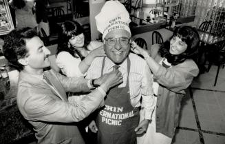 That time again: Johnny Lombardi, centre, the leading spirit of the CHIN picnic, is fussed over by his children, from left, Lenny, Donina and Theresa