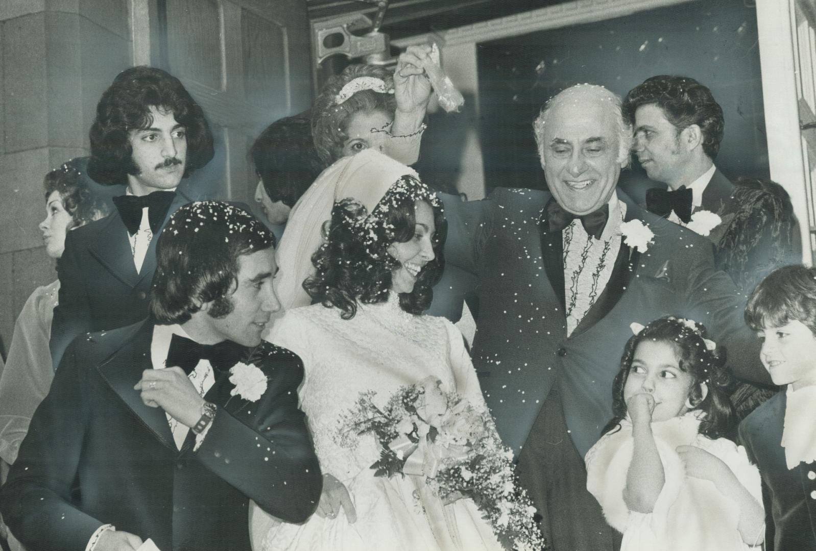 Shy flower girl Donina Lombardi, 6, shares a joke with her sister Theresa, who was married Saturday in St