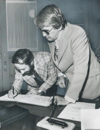 Less than four hours after an injunction to bar him from the Ontario Legislature was denied by the Ontario Supreme Court, Tony Lupusella (left) was sworn in officially as MPP for Dovercourt riding by Roderick Lewis, Clerk of the Legislative Assembly