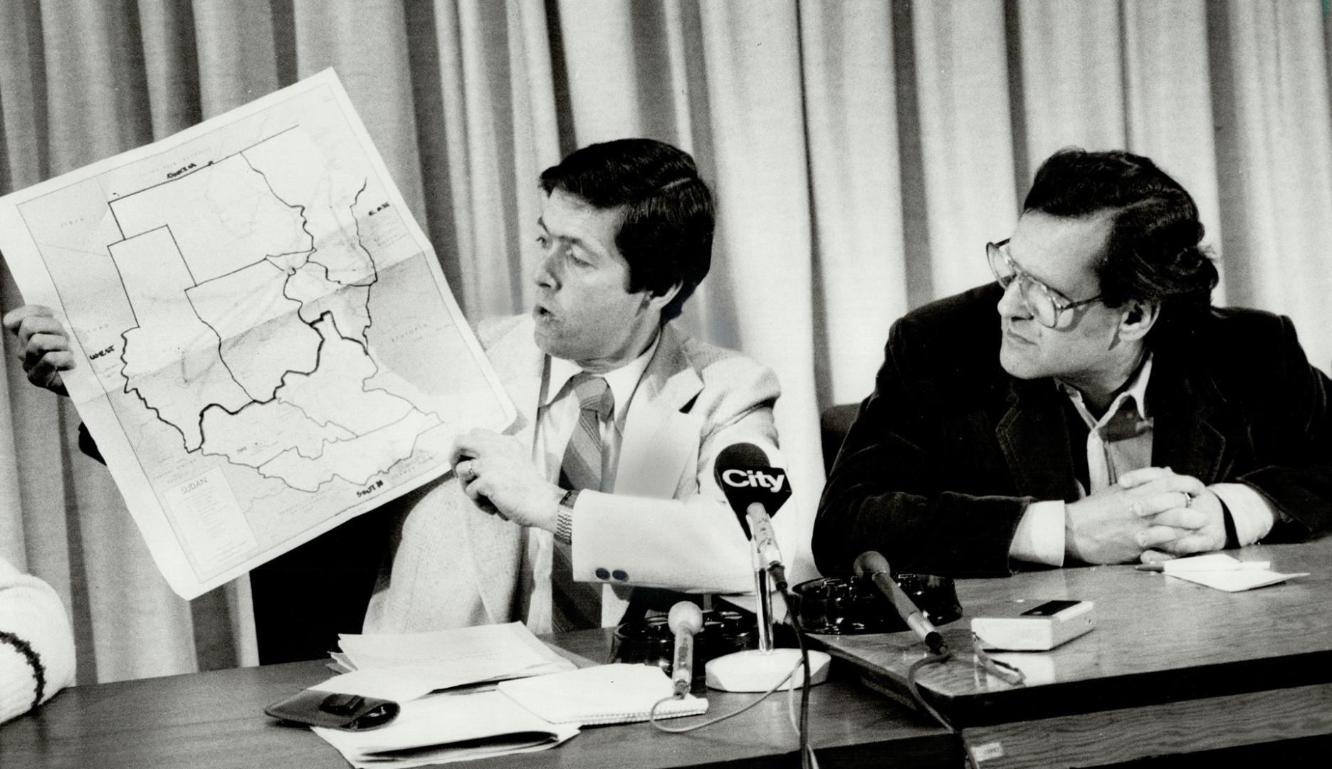 Action urged: David Macdonald, director of Ottawa's African famine-relief program, shows areas of Sudan visited by a Canadian fact-finding delegation to Sudan, as Stephen Lewis, Canada's ambassador to the United Nations, looks on yesterday