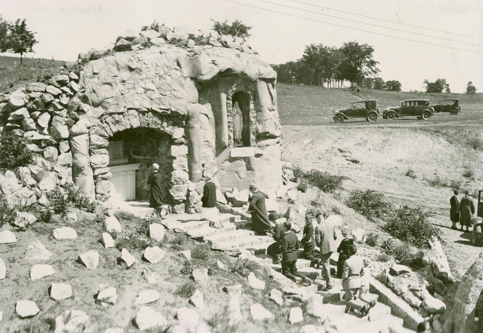 Interesting scene at the Martyrs' Shrine at Midland, Ont., showing pilgrims kneeling in worship before the figure of the Virgin