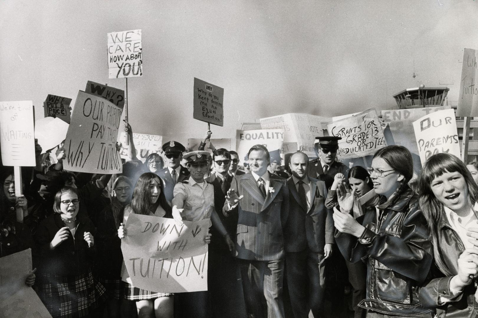 Making no commitment, Ontario Premier William Davis (centre) gives a friendly wave as he walks among crowd of demonstrating Catholic high school stude(...)