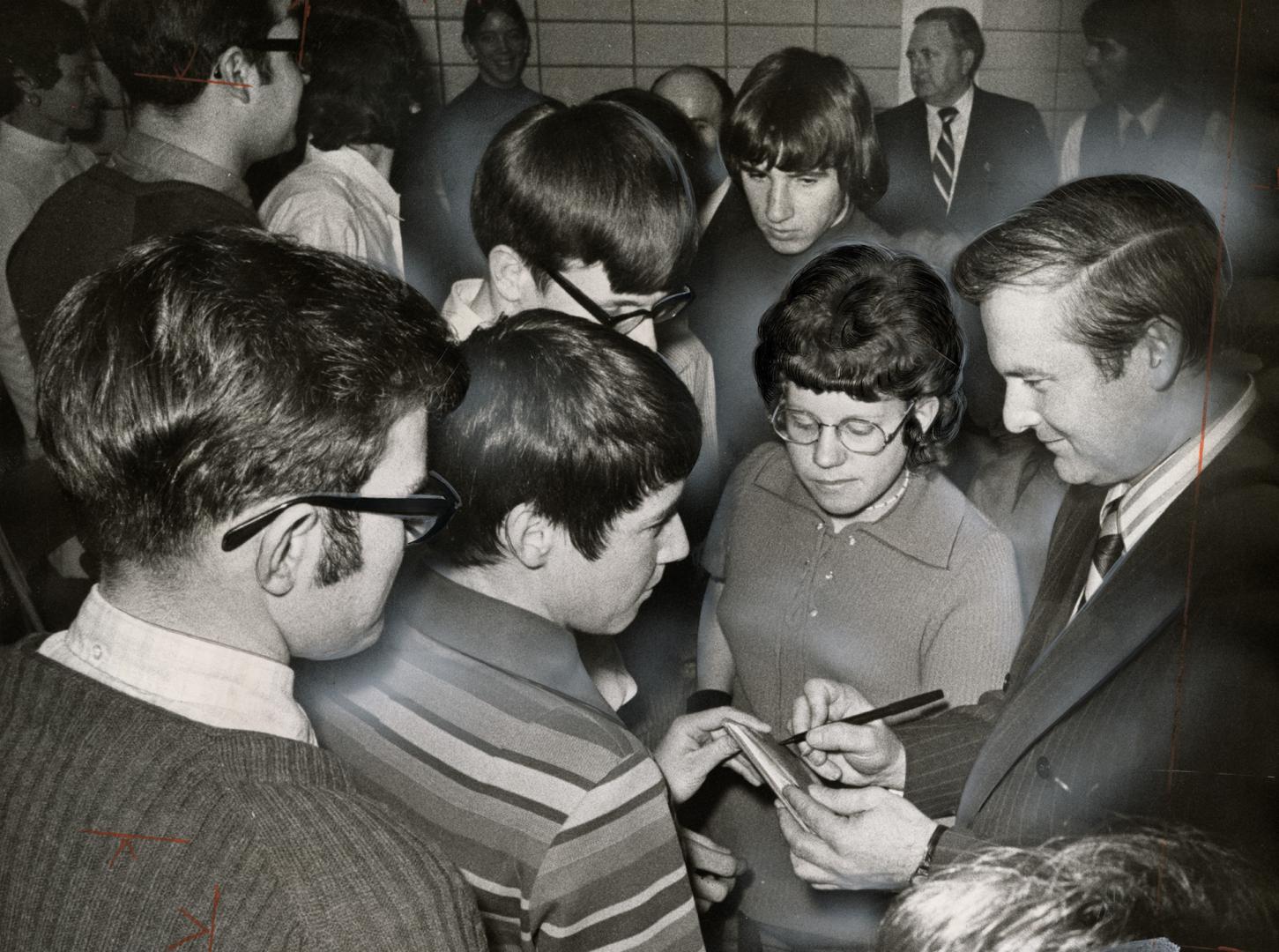 Talking to students in Port Colborne, Ontario's premier-designate William Davis signs autographs after his first speech since being chosen to succeed (...)