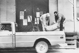 Charlie McCormick and Lee Parliament loading feed onto a truck. Alliston, Ontario