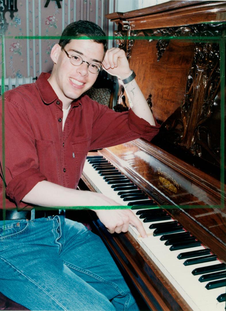 Curator of Bowmanville Museum Charles Taws on Dominion piano, Bowmanville, Ontario