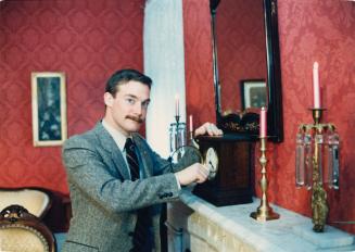 Curator Don Hoffman winds an antique clock at the Bowmanville Museum. Bowmanville, Ontario