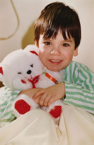 Joseph Barbosa cuddling a bear before surgery at Peel Memorial Hospital. Brampton, Ontario