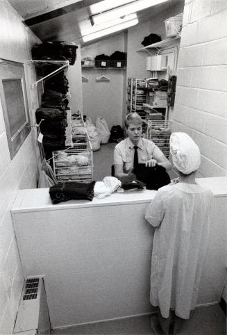 Eileen Wingate hands clothes to a new inmate at the Vanier Centre for Women. Milton, Ontario