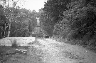 Image shows a bridge site with trees on both sides.