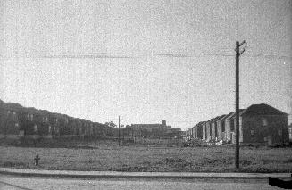 Image shows a street view with a few rows of houses.