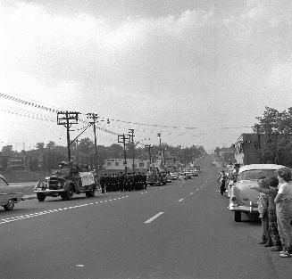 Image shows a parade along the street.