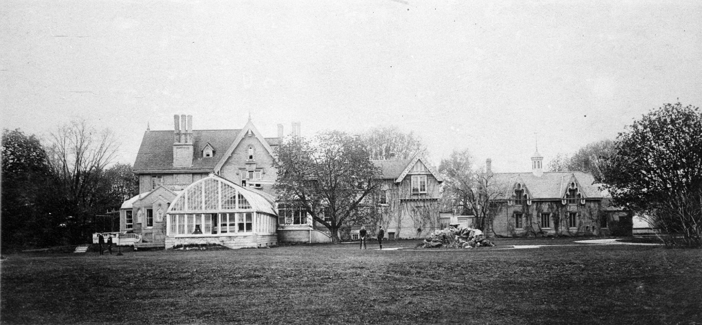 Image shows a few residential houses with some trees on both sides.