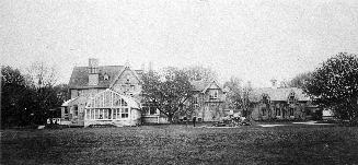 Image shows a few residential houses with some trees on both sides.