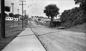 Image shows a street view with a sidewalk on the left.