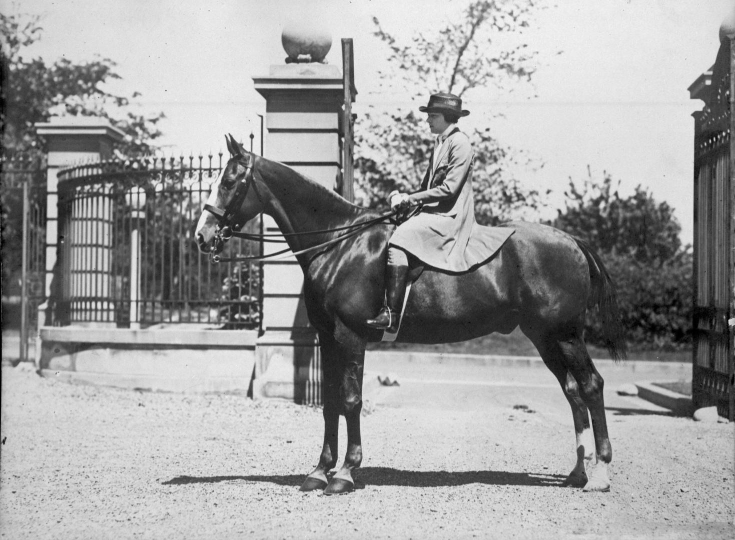 Image shows a person on the horse by the open gates.