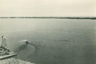 Image shows a lake view with a small boat close to the Harbour.