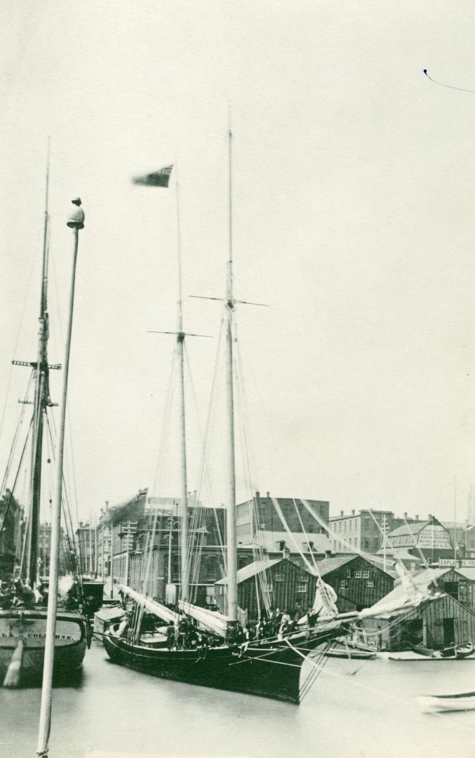 Image shows a few boats on the lake with the wharf in the background.