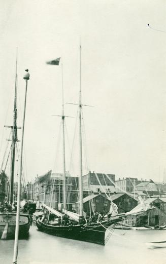 Image shows a few boats on the lake with the wharf in the background.