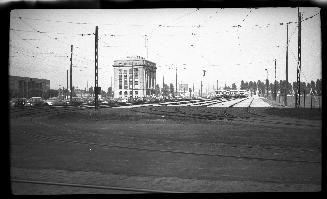 Image shows a street view with a few buildings and some streetcars in the background.