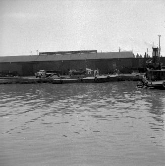 Image shows a lake view and the docking area with a few small boats around.