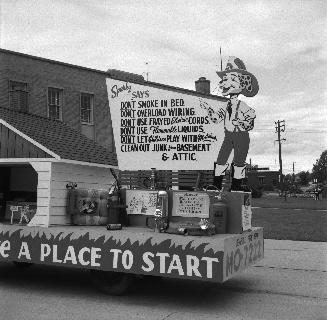 Image shows a fire prevention week parade vehicle decorated with signs that read " Don't smoke …