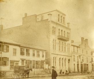 Bay St., west side, looking north to King Street West, showing Daily Telegraph buildings centre, cart of George Coleman, confectioner, and far right Robert Davis & Co. grocer. Toronto, Ont