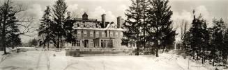 Image shows a big house with a number of trees and lots of space around it.