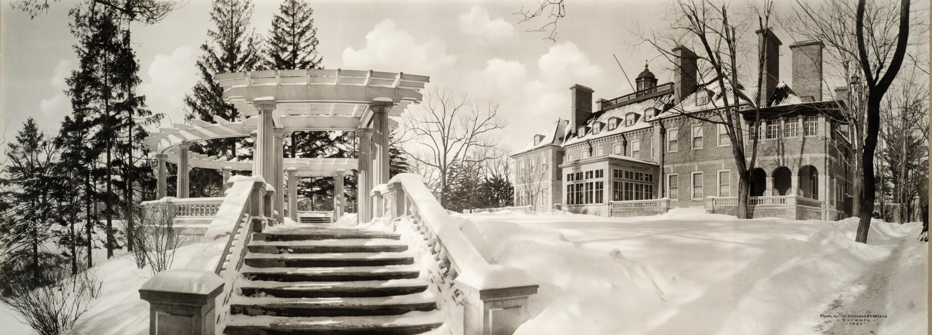 Image shows a staircase in winter with a house on the right.