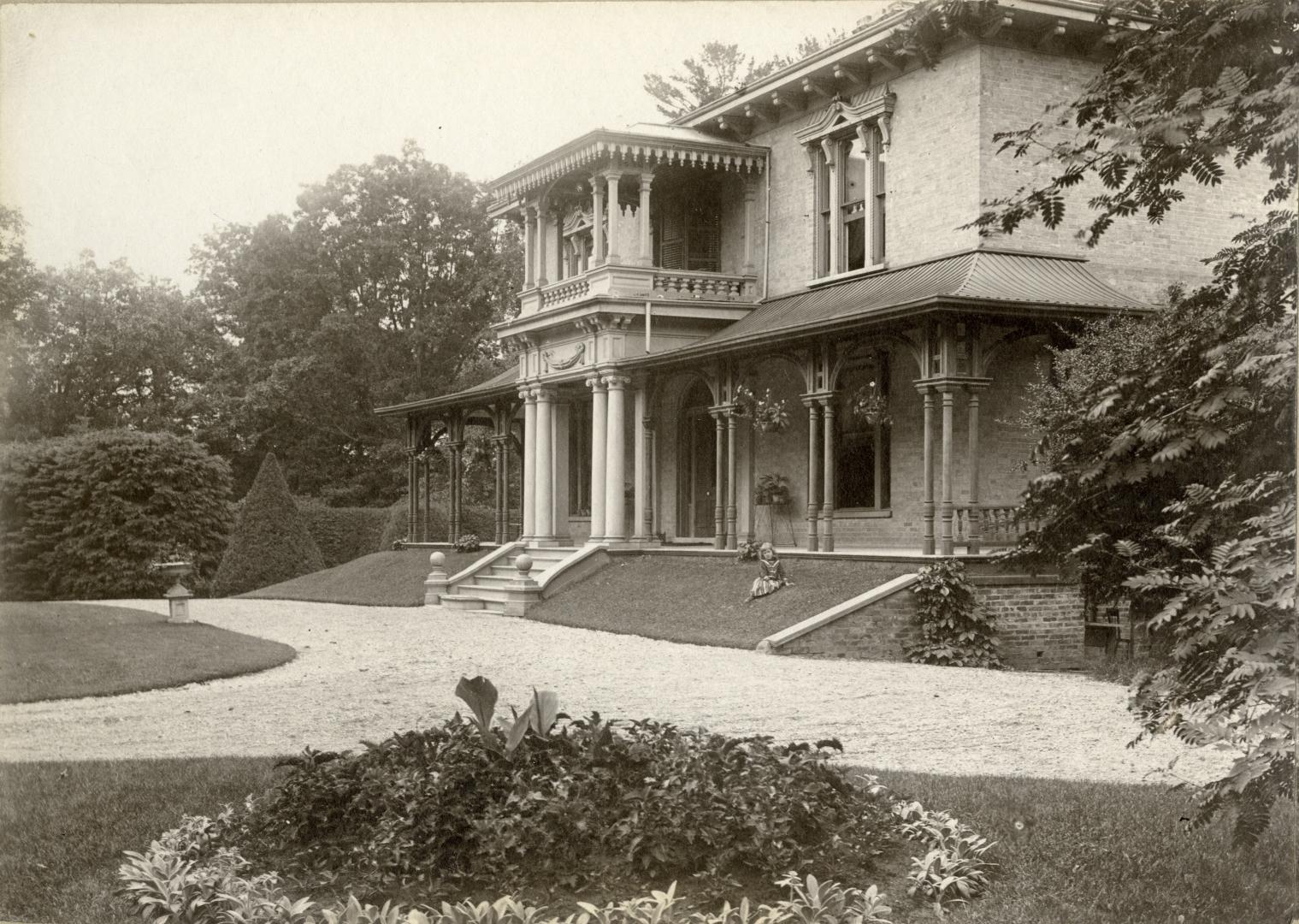 Image shows a limited view of a two storey house with some trees around it.