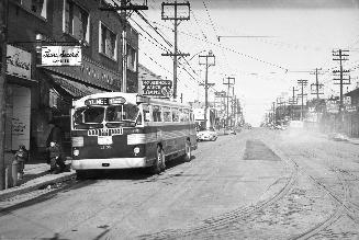 T.T.C., bus #1358, on Yonge St., looking north from Eglinton Ave. Image shows a city bus parked…