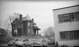 Image shows a two storey residential house on a small hill.