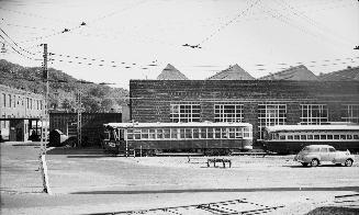 Image shows a few rail cars beside the building. 