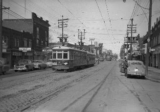 Yonge Street looking north from Roslin Avenue. Image shows a street view with a streetcar on th…