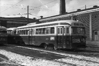 Image shows a few rail cars beside the building. 