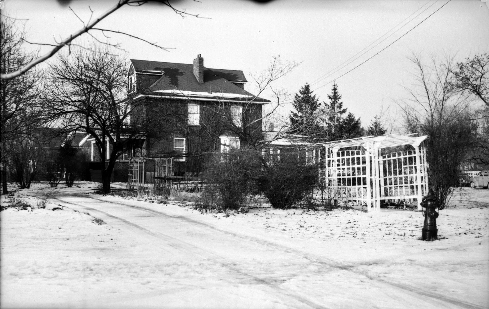 Image shows a two storey residential house in winter.