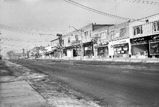 Image shows a street view with low rise buildings on the right side.