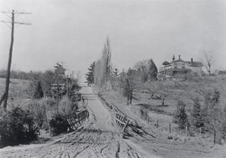 Bayview Avenue, looking north from Eglinton Avenue East. Image shows an unpaved road going up a…