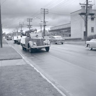 Image shows parade vehicles on the street.