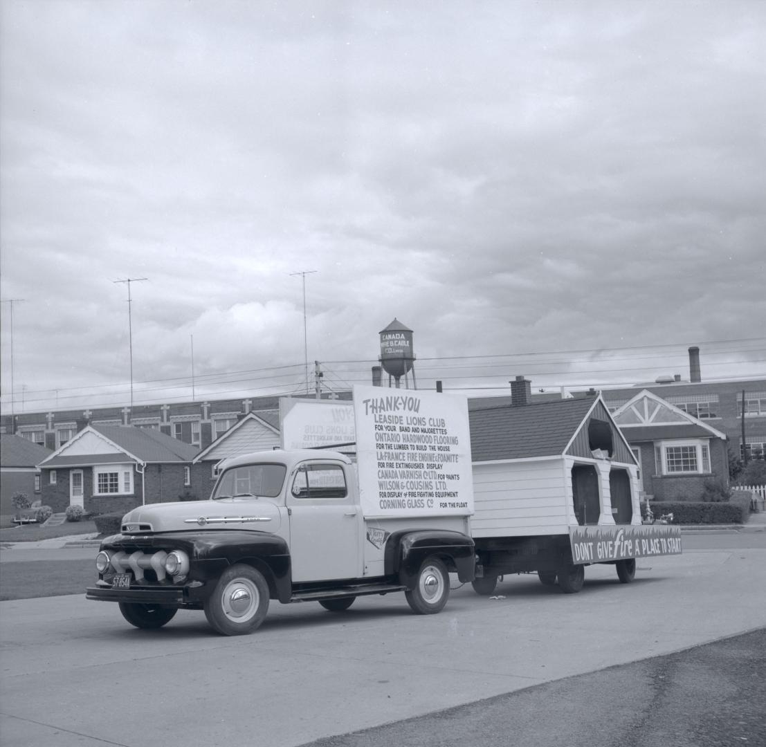 Image shows a vehicle participating in a parade that carries some signs.