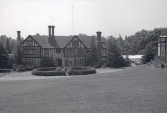 Image shows a three storey residential house with a big garden in front of it.