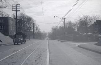 Image shows a street view with houses on both sides.